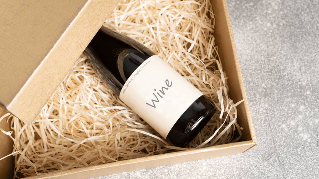 Wine subscription gift box with red and white wine bottles on table